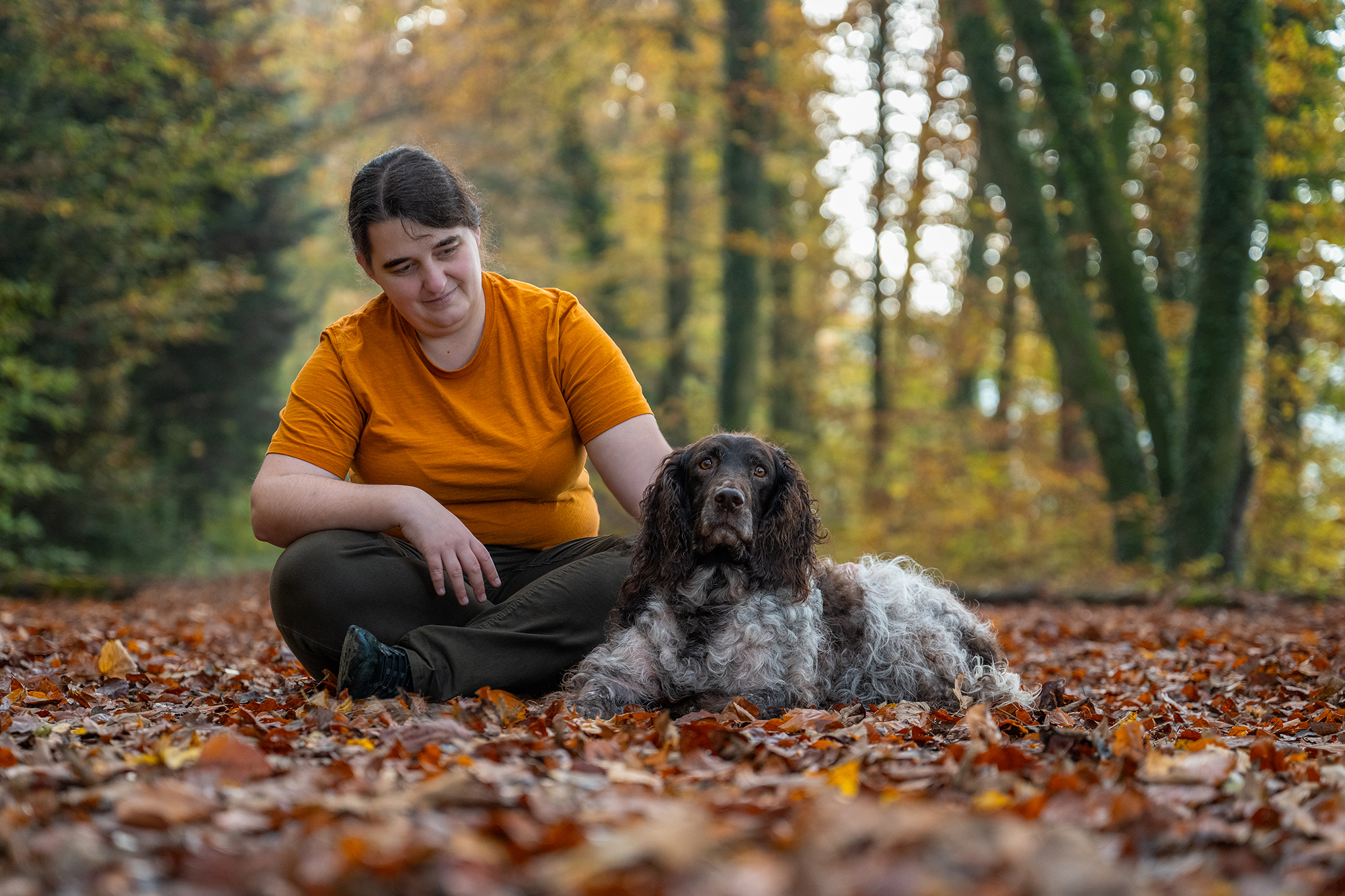 Frau mit Hund im Herbstwald