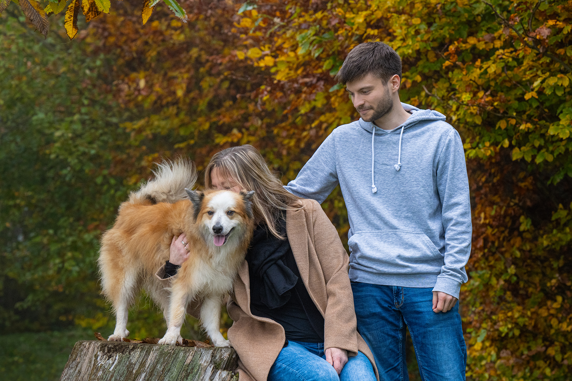 Frau und Mann kuscheln mit Hund