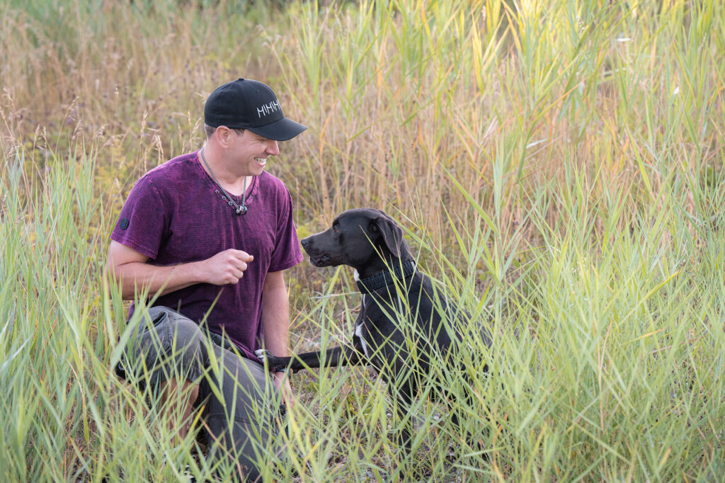 Mann mit Hund im Schilf