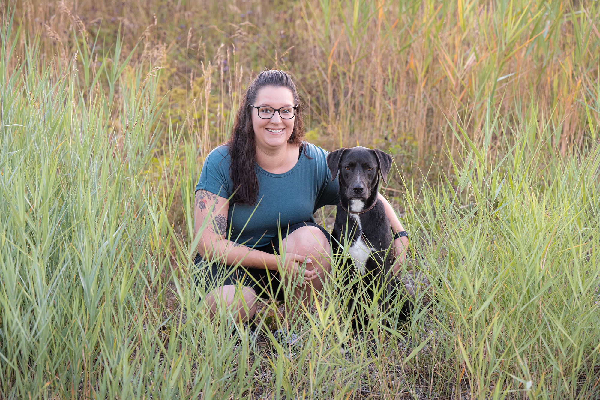 Frau mit Hund im Schilf