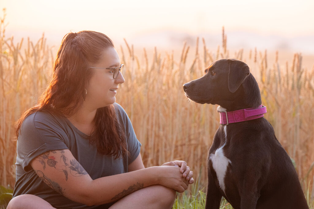 Frau mit Hund im Sonnenaufgang
