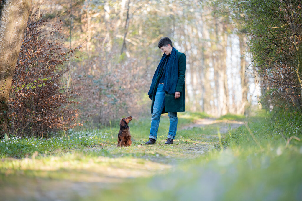 Dackel und Frau auf Spaziergang