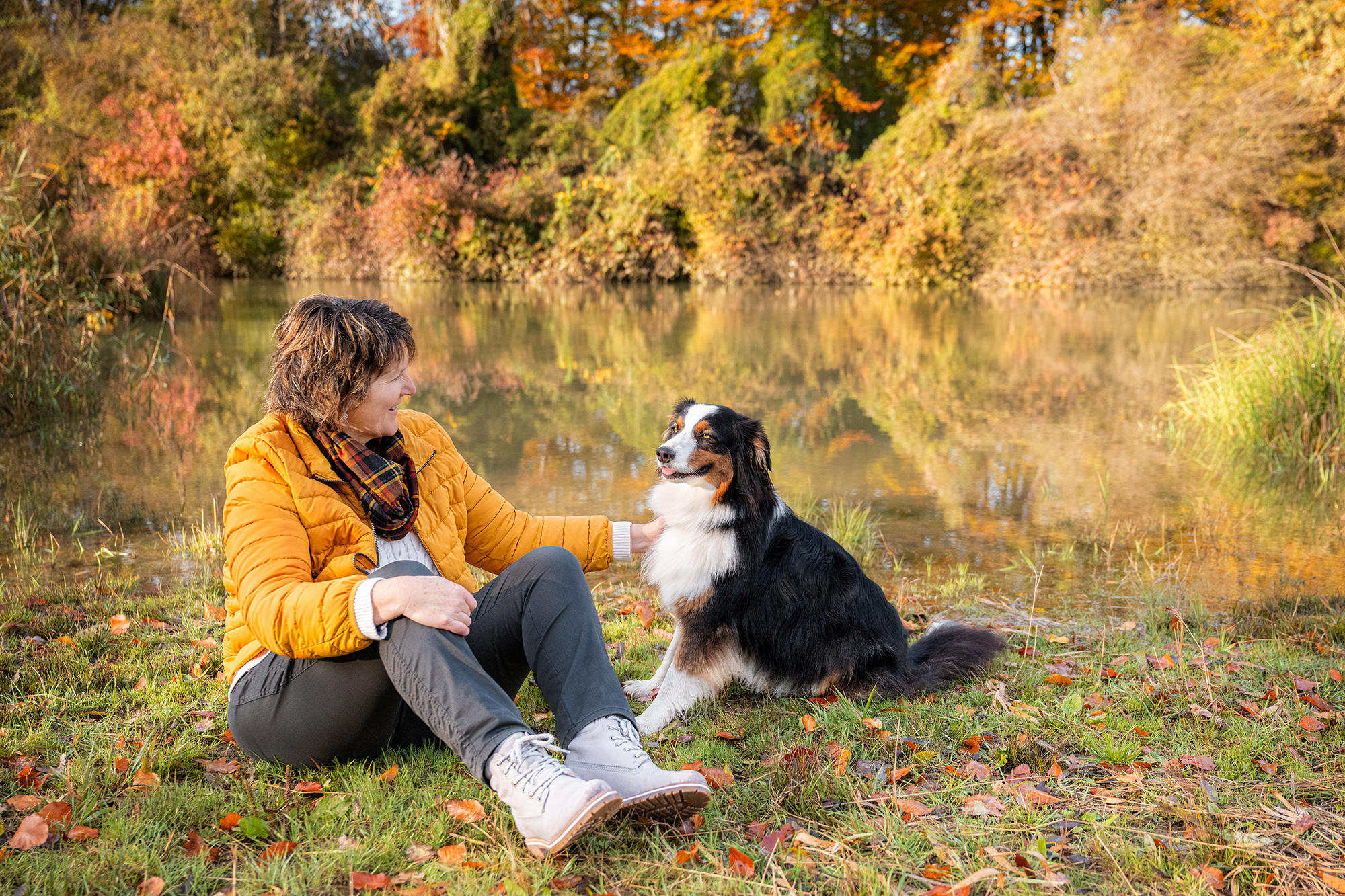 Frau mit Hund am Wasser